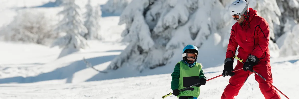 Moniteur de ski encadrant un enfant sur les pistes