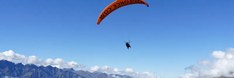 Parapentiste au-dessus du lac et des montagnes