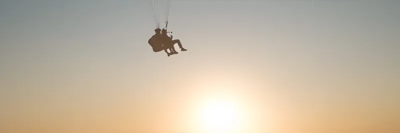 Vol biplace en parapente au coucher du soleil