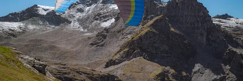 Parapentes colorées dans le ciel au-dessus des montagnes