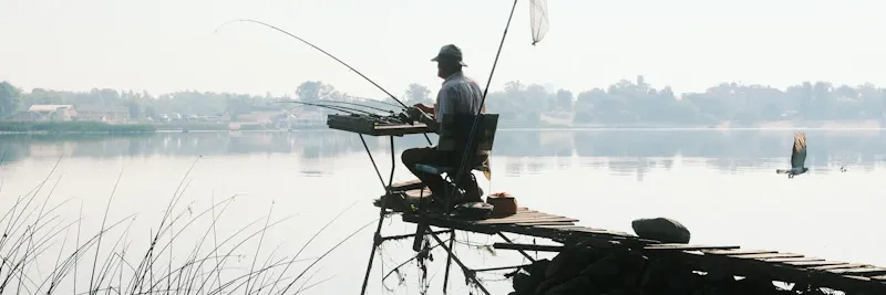 Pêcheur capturant un poisson dans la rivière au petit matin