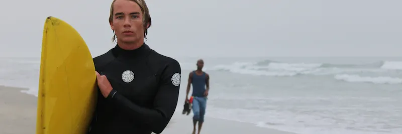 Moniteur de surf enseignant à un groupe sur la plage