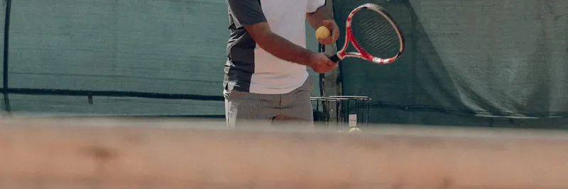 Panier de balles de tennis sur court en terre battue