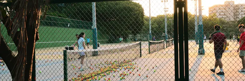 Coach de tennis sur court extérieur au coucher du soleil
