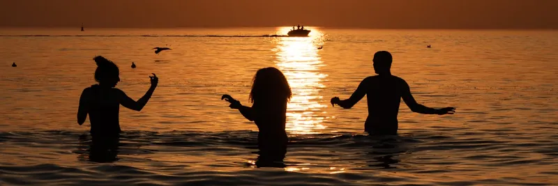 Groupe d'enfants en Optimist au coucher de soleil