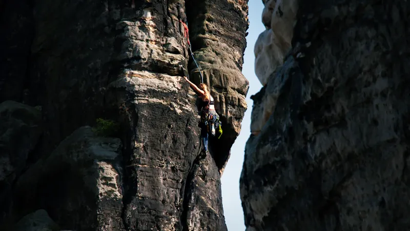 Guide préparant le matériel d'escalade au pied d'une falaise