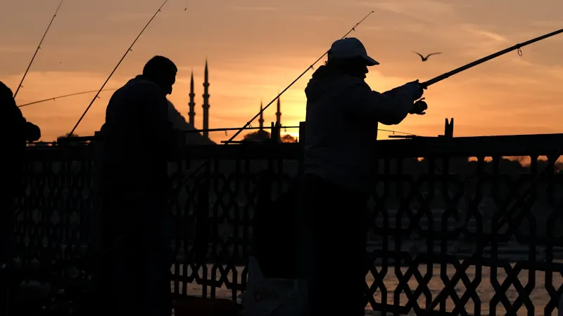 Guide de pêche lançant sa ligne au lever du soleil