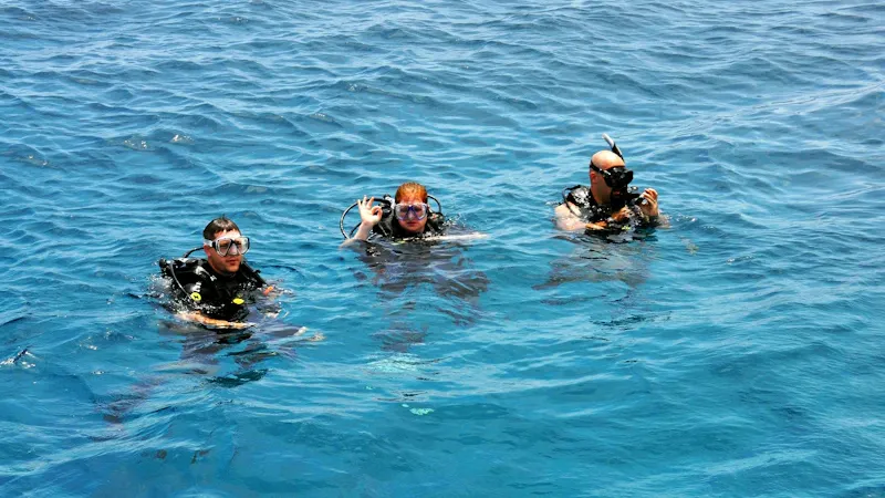 Moniteur de plongée aidant un plongeur à s'équiper sur le bateau