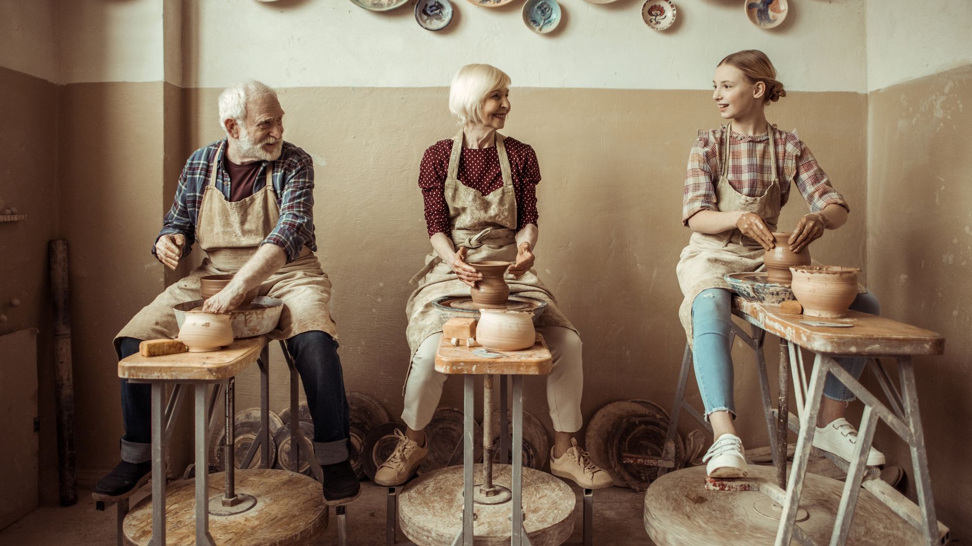 Grands-parents faisant de la poterie avec leur petite-fille dans un atelier