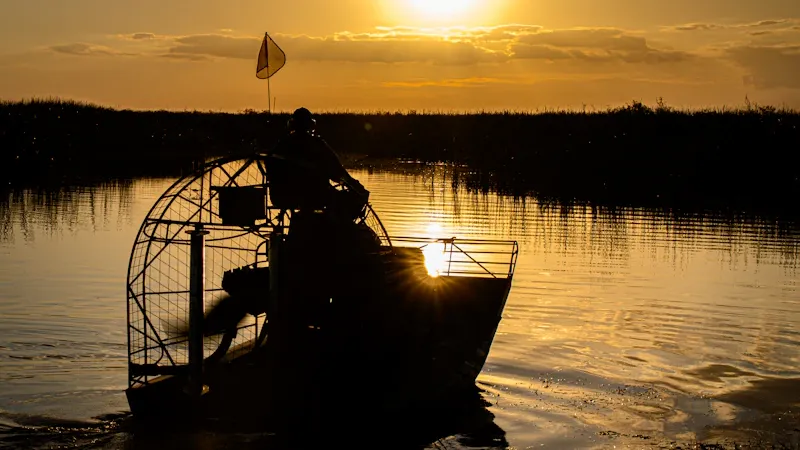 Guide de pêche et client au bord de la rivière au coucher du soleil