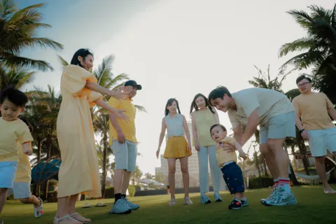 Groupe d'enfants en école de golf avec moniteur et drapeaux de couleur