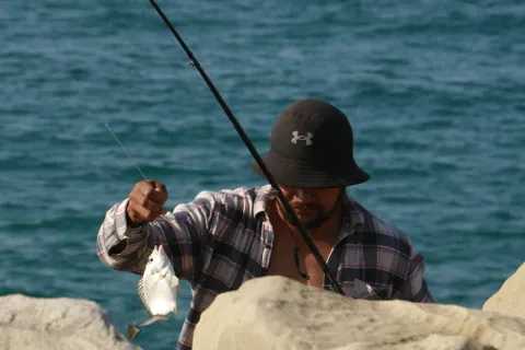 Matériel de pêche à la mouche posé sur des rochers