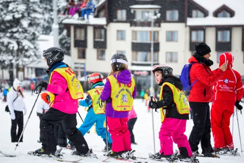 Enfants en cours de ski dans une station alpine