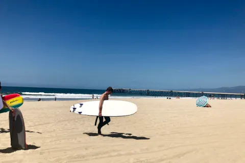 Moniteur de surf expliquant les techniques sur le sable