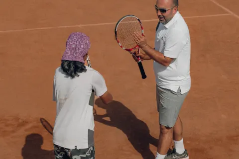 Coach corrigeant le geste d'un élève adulte