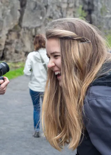 Guide-conférencière souriante devant un monument