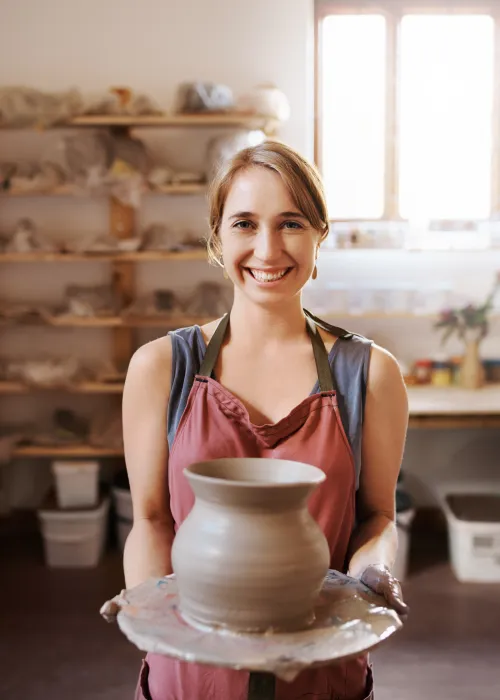 Artisan fier de son travail dans un atelier de poterie