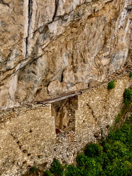 Grimpeur sur une paroi calcaire avec vue sur la vallée