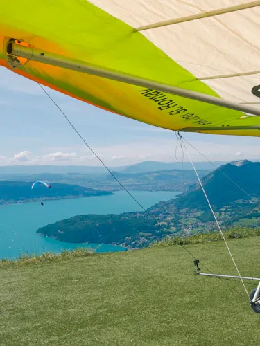 Parapentiste biplace au-dessus du lac d'Annecy au lever du soleil