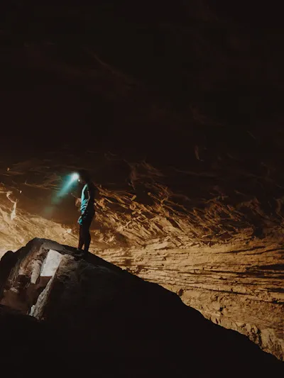 Groupe de spéléologues s'engouffrant dans une grotte avec leurs lampes frontales