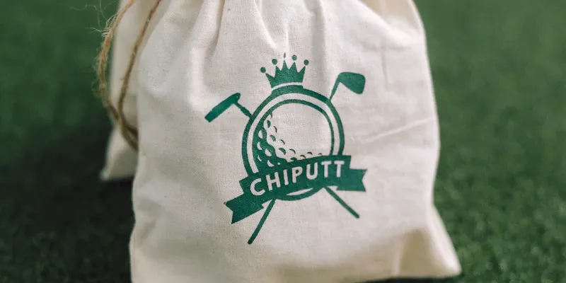 Sac de golf et clubs posés au bord du putting green au soleil