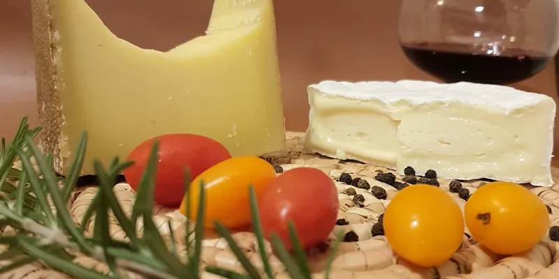Groupe souriant autour d'une table de dégustation avec fromages et charcuterie sur ardoise