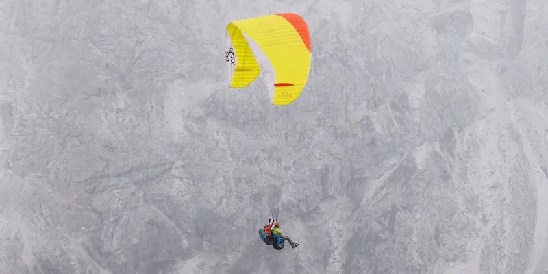 Voiles de parapente colorées alignées sur un site de décollage en montagne