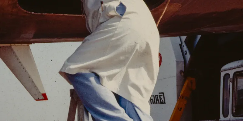 Moniteur aidant un passager à s'installer dans la sellette avant le décollage