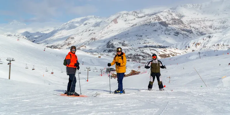 Skieurs adultes en cours collectif avec vue montagne