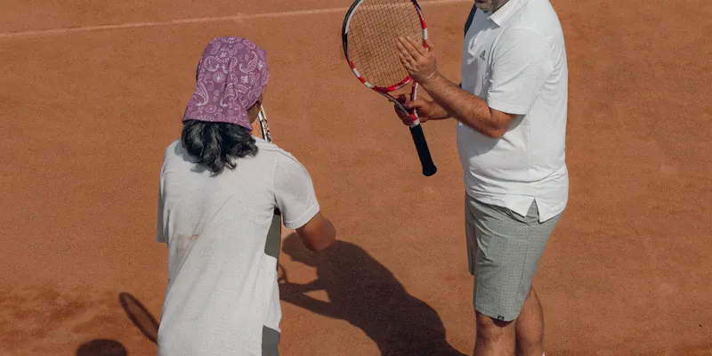 Groupe d'enfants en mini-tennis avec moniteur