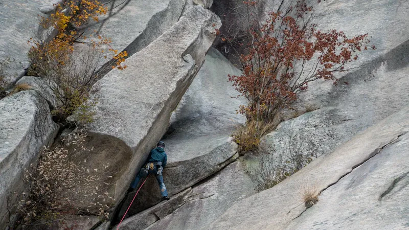 Grimpeur en grande voie sur falaise calcaire