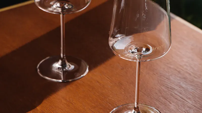 Verres de dégustation alignés sur une table en bois avec lumière tamisée