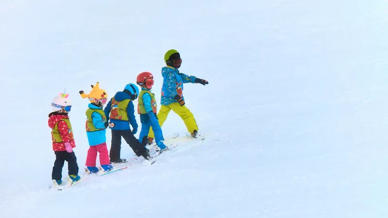Moniteur et groupe d'enfants sur la piste