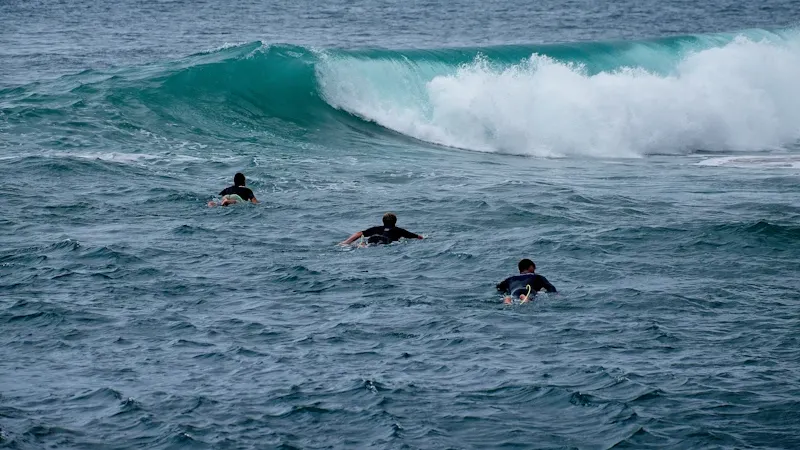 Cours collectif de surf avec moniteur dans les vagues