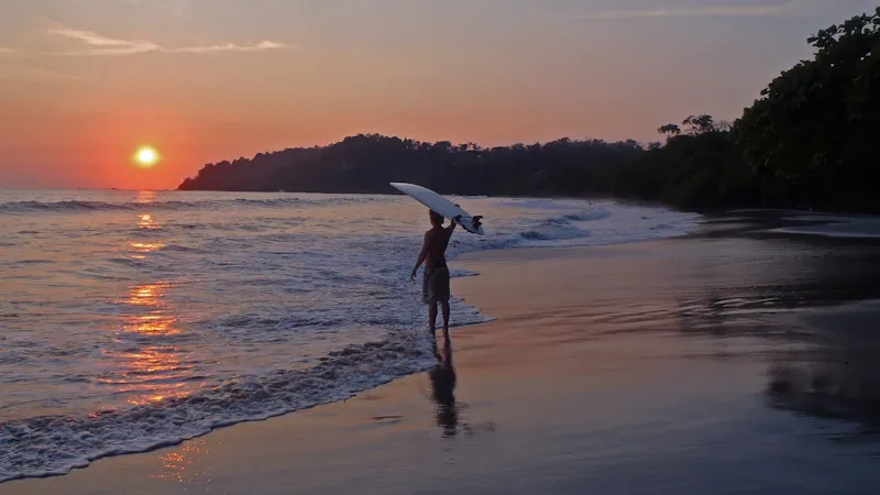 Surfeurs débutants sur la plage au coucher du soleil