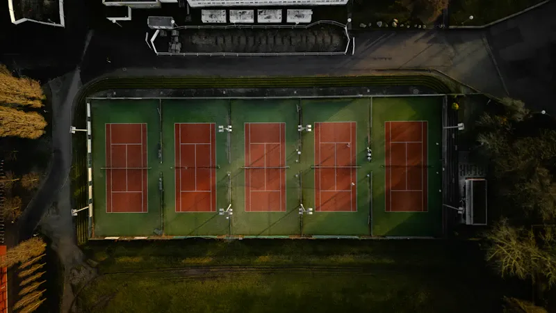 Courts de tennis en terre battue au soleil couchant