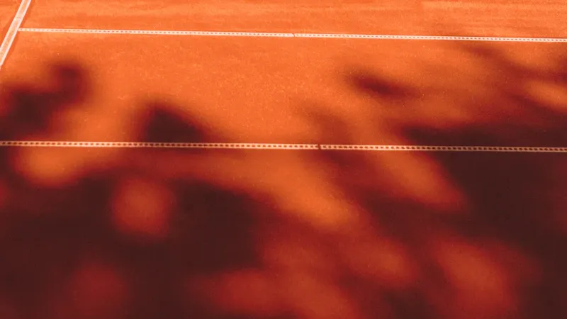 Court de tennis en terre battue au soleil couchant